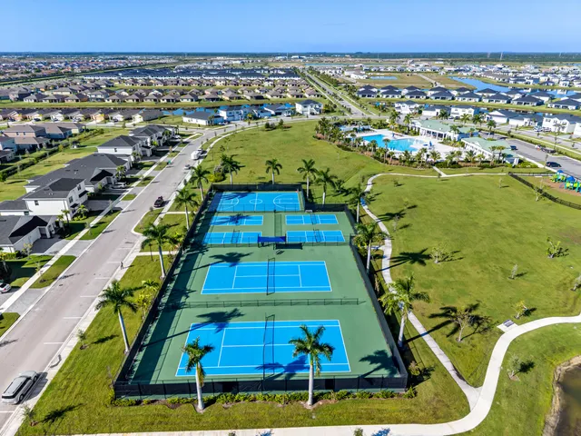 an aerial view of residential houses with outdoor space and trees