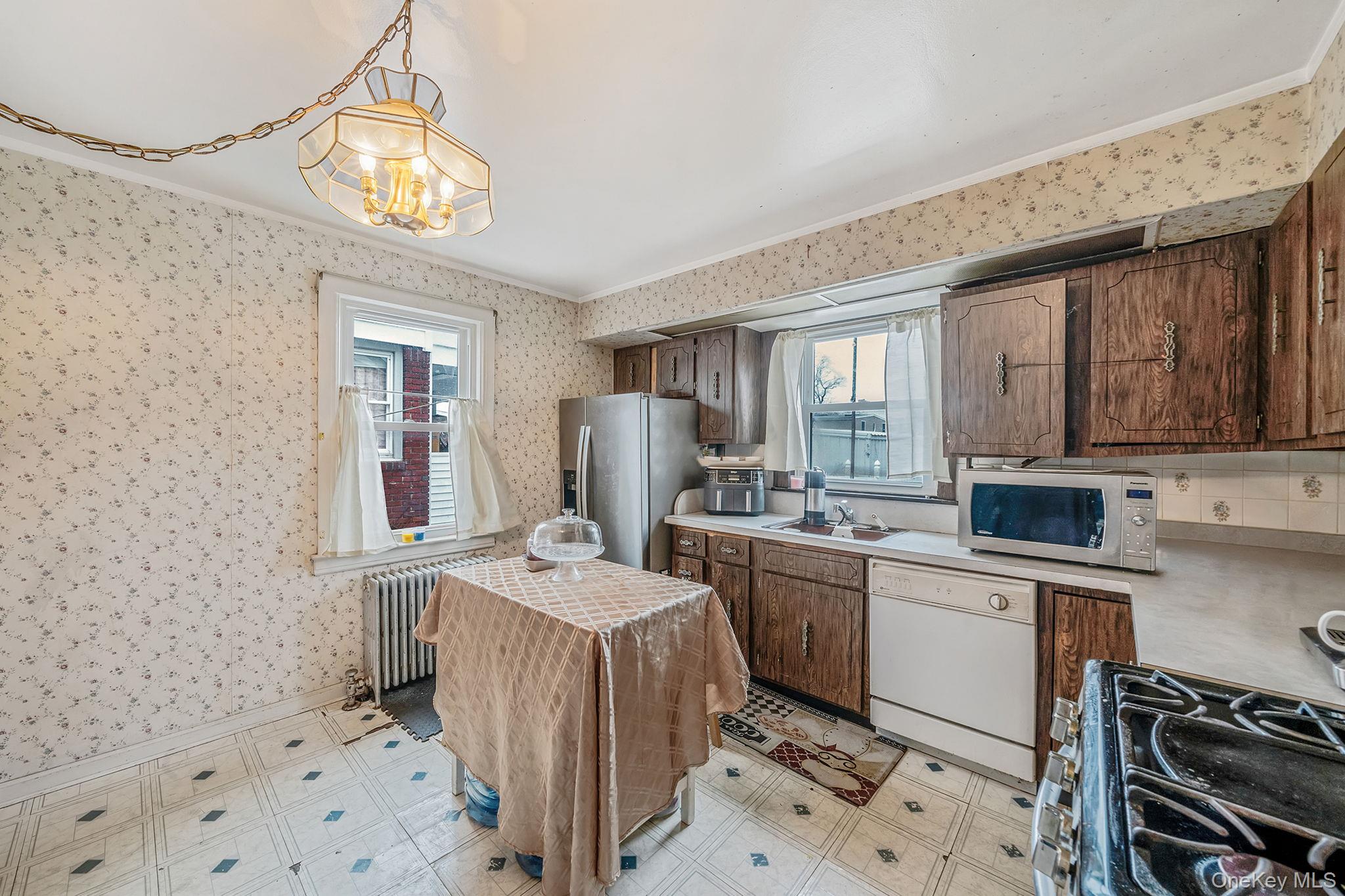 12 Edna Court Valley Stream, NY 11580 - Photo 9 of 20 a room with a sink a stove a refrigerator and cabinets