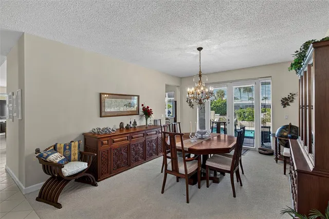 a dining hall with stainless steel appliances granite countertop a dining table and chairs with wooden floor