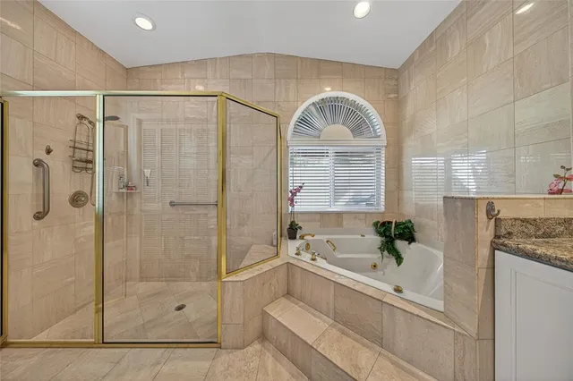 a living room with stainless steel appliances furniture a rug and a kitchen view