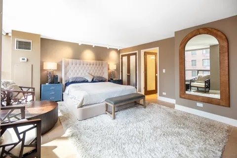 a spacious bedroom with a bed couch and a large window