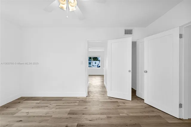 a view of an empty room with wooden floor