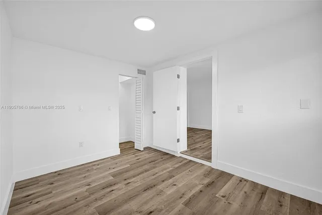 a view of an empty room and wooden floor
