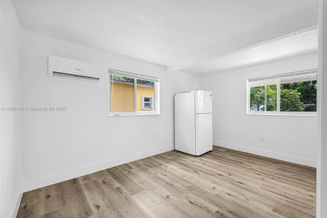 an aerial view of a city with lots of residential buildings ocean and mountain view in back