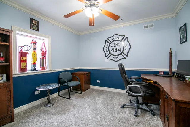 a view of a workspace with furniture and a window