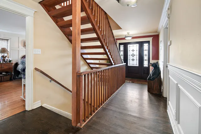 a view of a hallway with wooden floor and stairs
