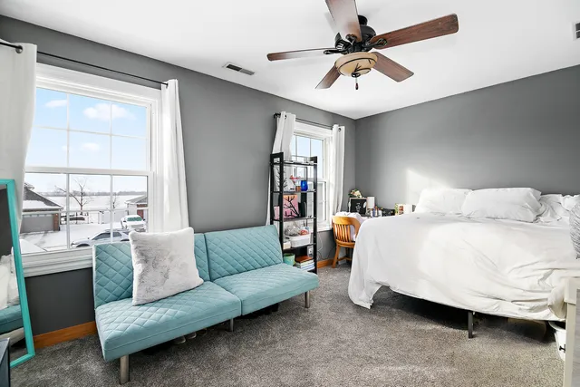 a bedroom with a bed a couch and a window