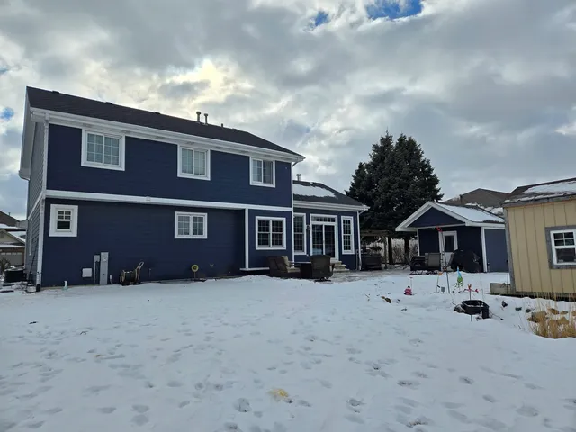 a front view of a house with a yard covered in snow