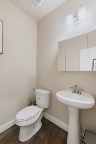 a bathroom with a toilet a sink and mirror