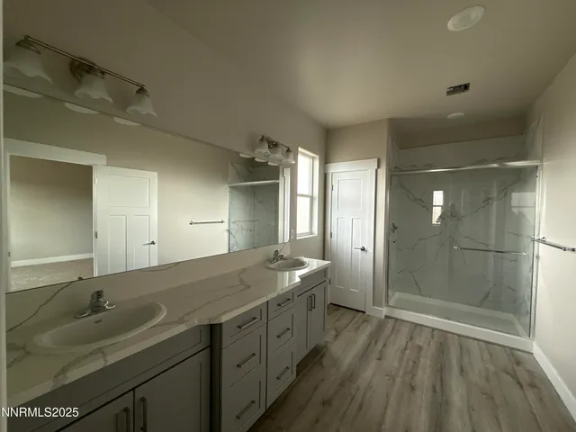 a spacious bathroom with a double vanity sink and mirror