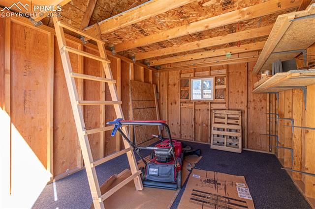 1775 Winnebago Road Colorado Springs, CO 80915 - Photo 27 of 32 Inside of shed with a ramp and ladder to second story storage