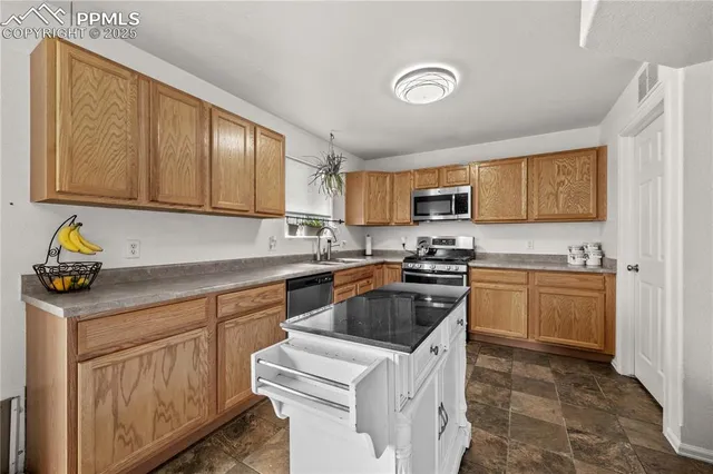 a kitchen with granite countertop a sink stove and cabinets