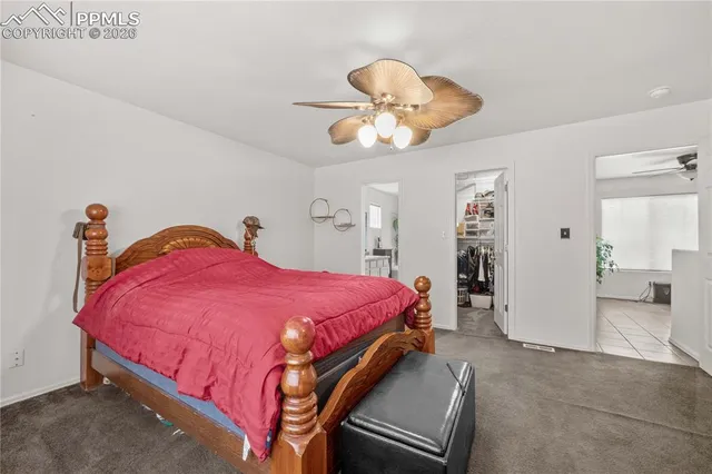 a spacious bedroom with a bed and a chandelier