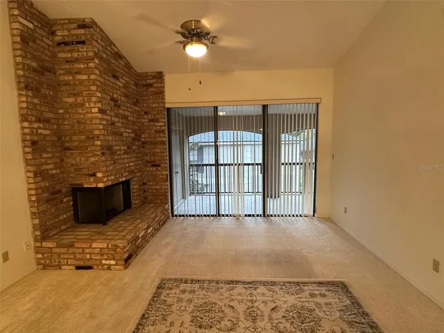 a view of an empty room with a fireplace and a rug