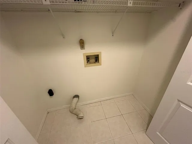 a room with water heater and racks on the wall