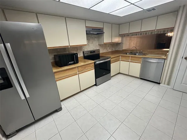 a kitchen with a sink a refrigerator and cabinets