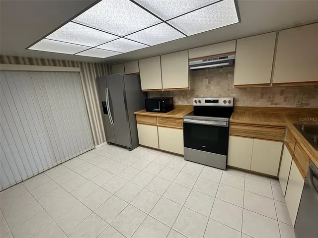 a kitchen with stainless steel appliances granite countertop a stove a sink and a refrigerator
