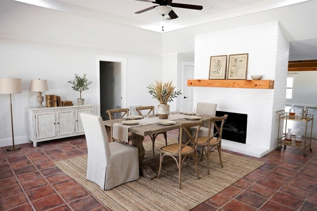 10575 Friendship Road Pilot Point, TX 76258 - Photo 7 of 32 Spacious dining area featuring terra cotta tile flooring and a white brick fireplace with a wood mantel