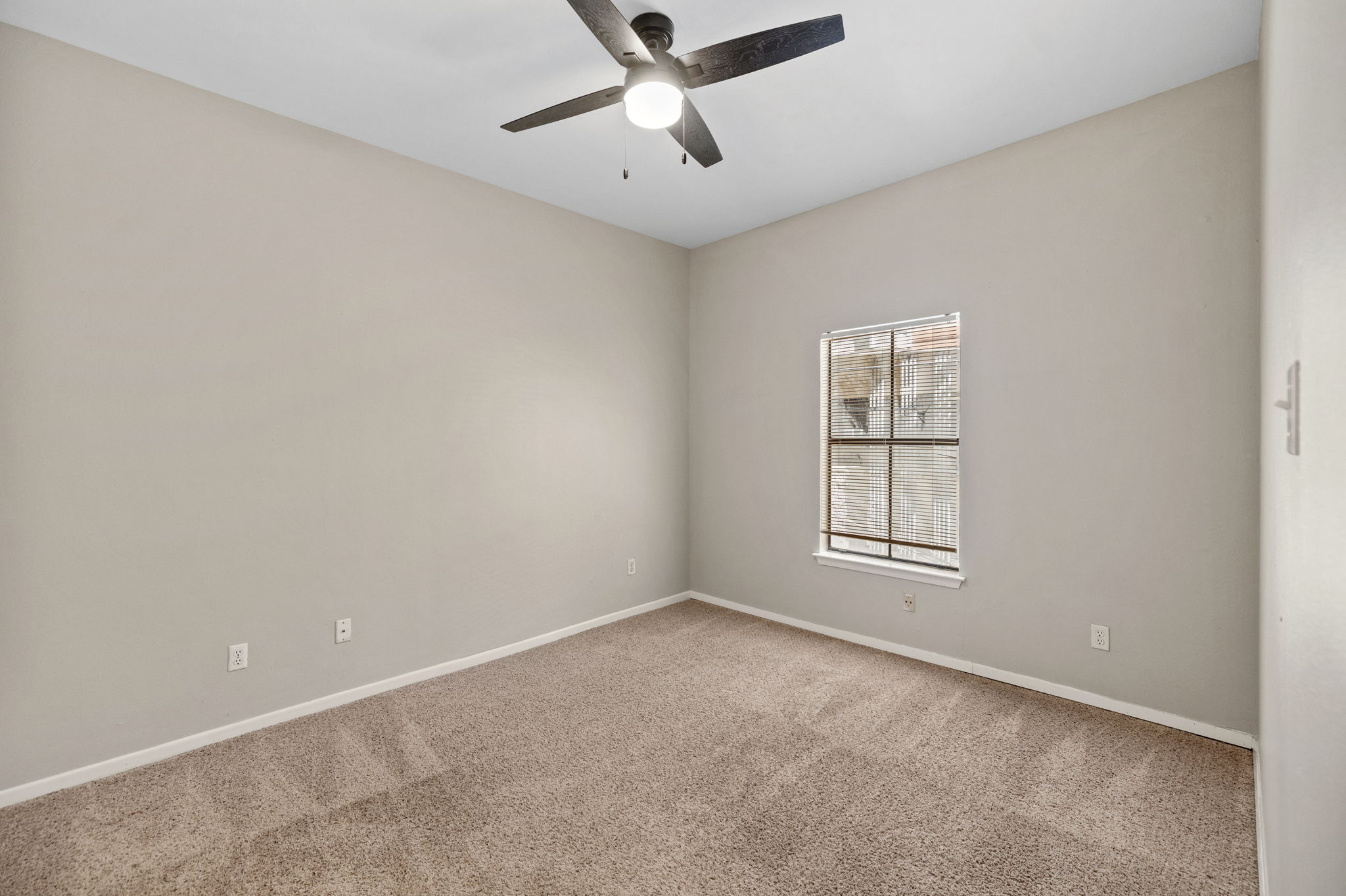 712 Graham Place, Unit 203 Austin, TX 78705 - Photo 15 of 30 an empty room with chandelier fan and windows