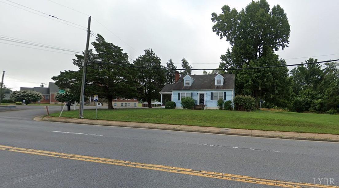 a view of a big house with a big yard and large trees