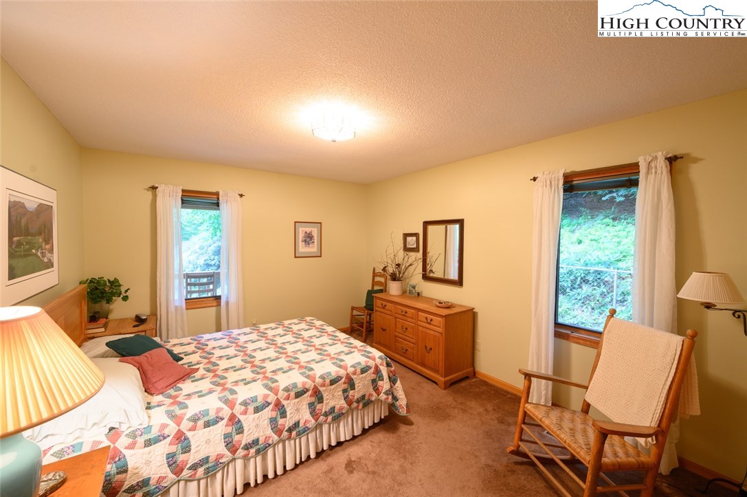 4081 Howard's Creek Road Boone, NC 28607 - Photo 17 of 44 a bedroom with a bed and wooden floor
