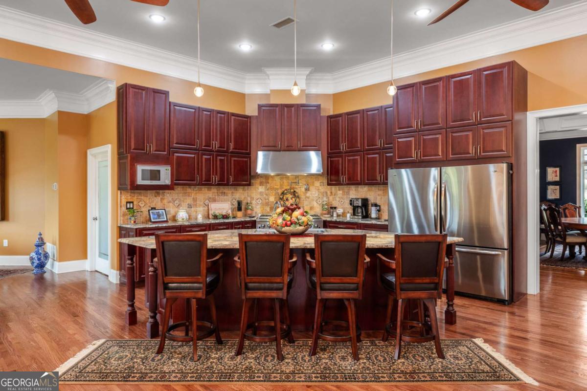 265 Honeysuckle Lane Temple, GA 30179 - Photo 13 of 46 a kitchen with stainless steel appliances kitchen island granite countertop a table chairs and a refrigerator