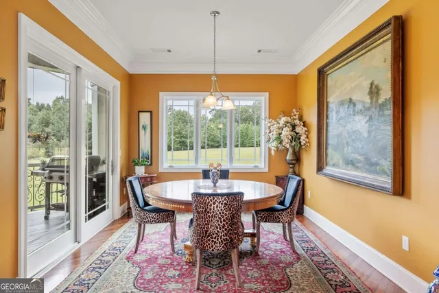 a dining room with furniture a chandelier and wooden floor