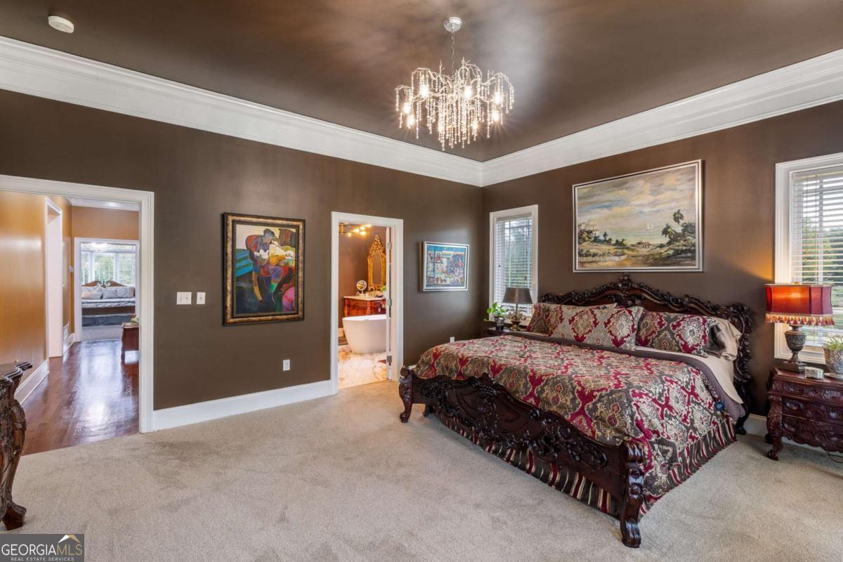 265 Honeysuckle Lane Temple, GA 30179 - Photo 19 of 46 a spacious bedroom with a large bed and a chandelier
