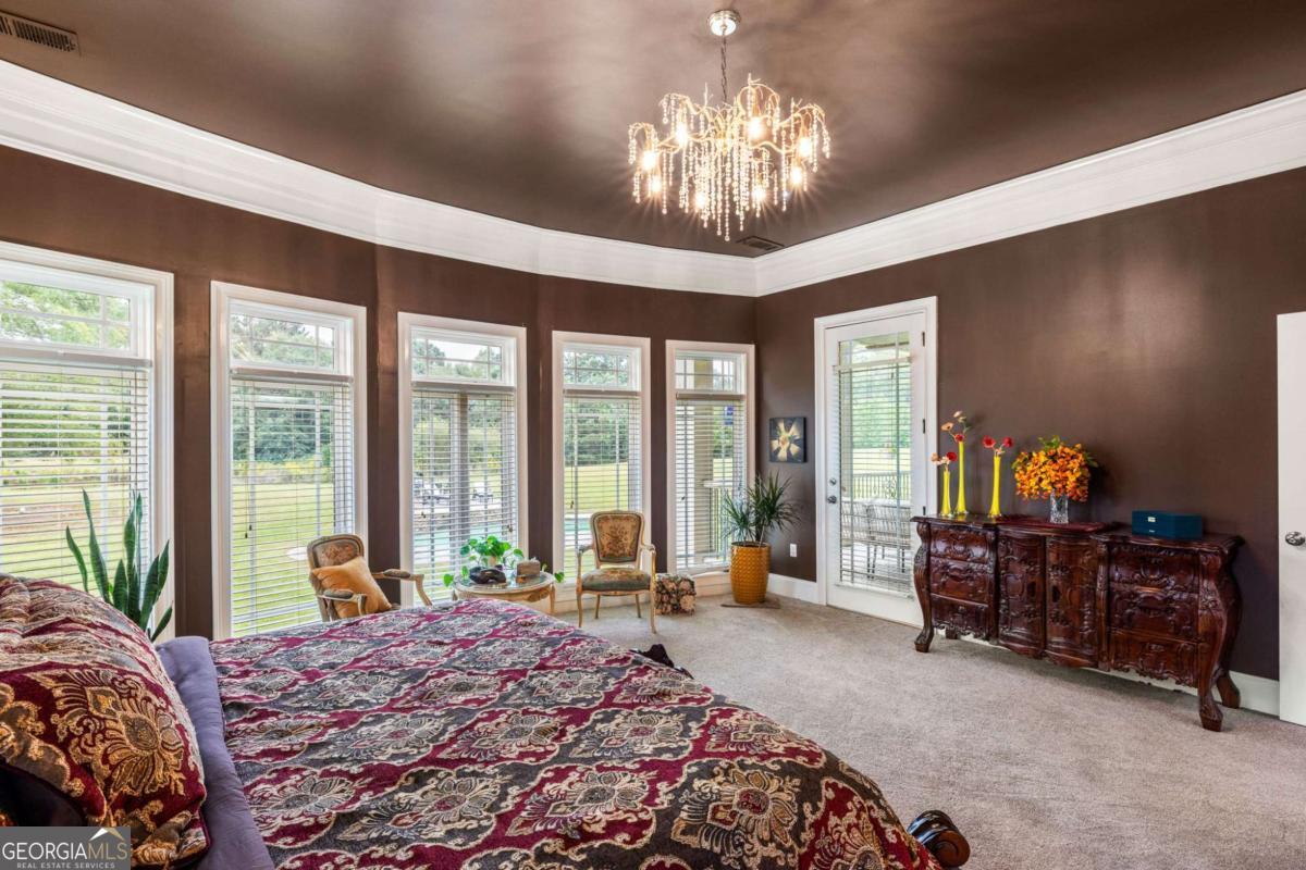 265 Honeysuckle Lane Temple, GA 30179 - Photo 20 of 46 a bedroom with a large bed and a chandelier