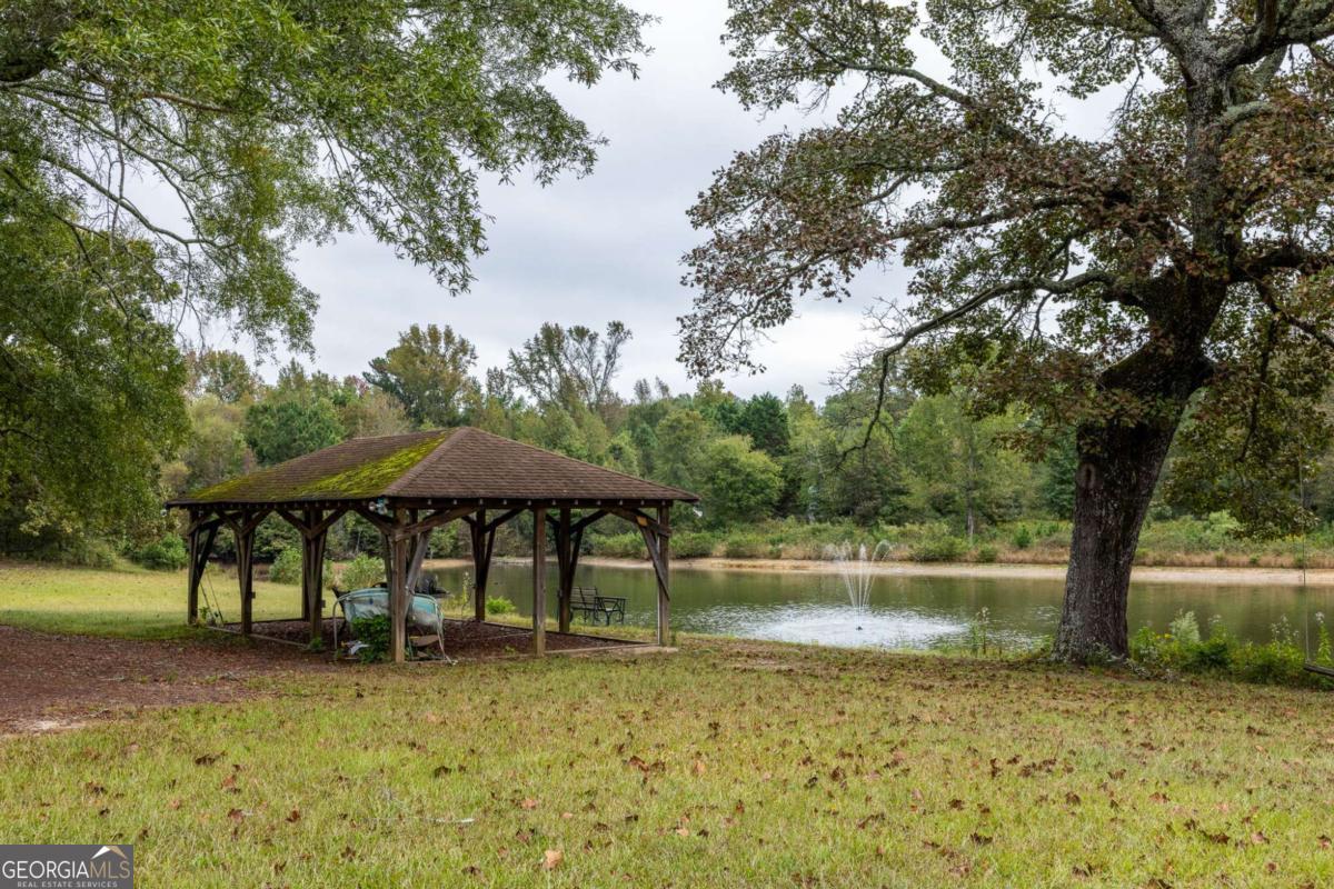 265 Honeysuckle Lane Temple, GA 30179 - Photo 38 of 46 a backyard of a house with table and chairs under an umbrella