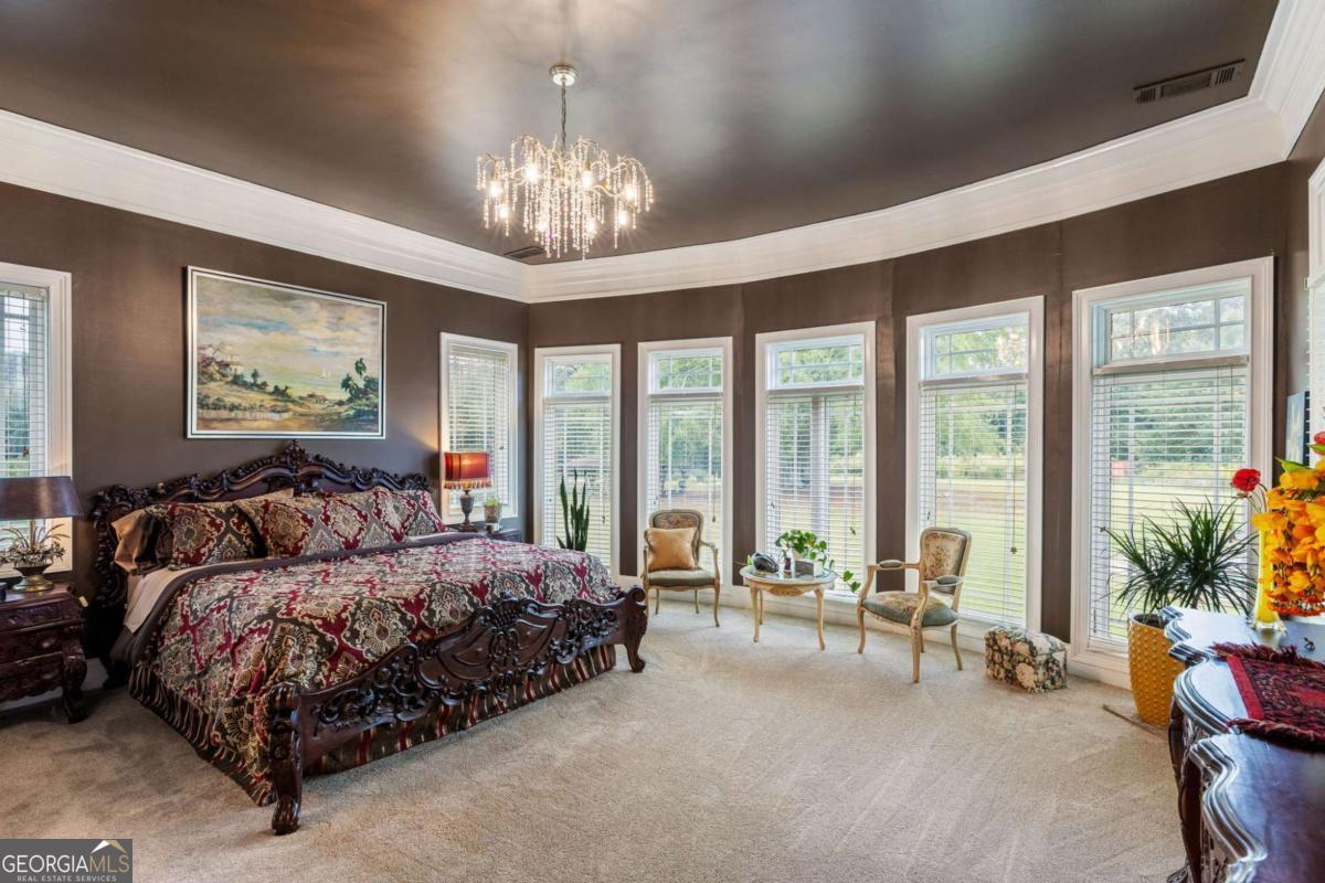 265 Honeysuckle Lane Temple, GA 30179 - Photo 5 of 46 a spacious bedroom with large bed and a chandelier