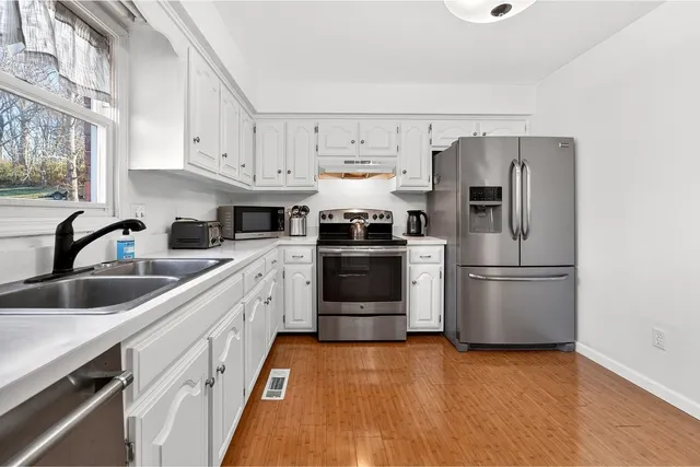a kitchen with stainless steel appliances a refrigerator sink and microwave