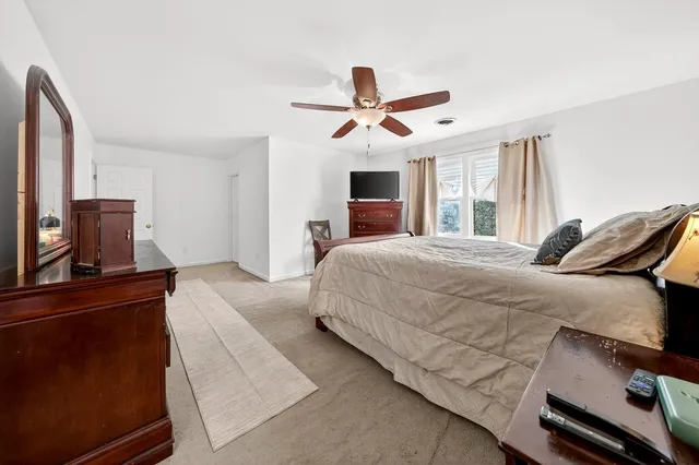 a bedroom with a bed dresser and a window