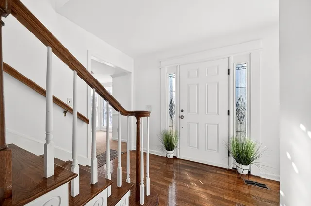 a view of an entryway with wooden floor and door