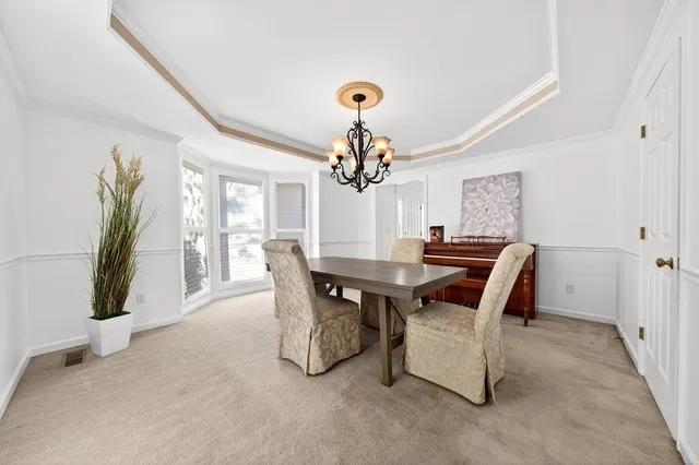 a view of a dining room with furniture and a chandelier