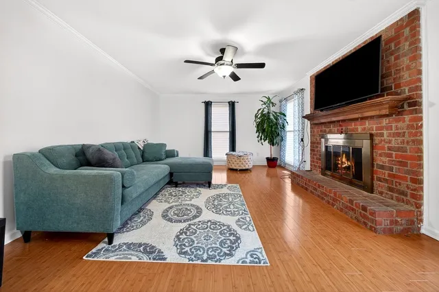 a living room with furniture a flat screen tv and a fireplace