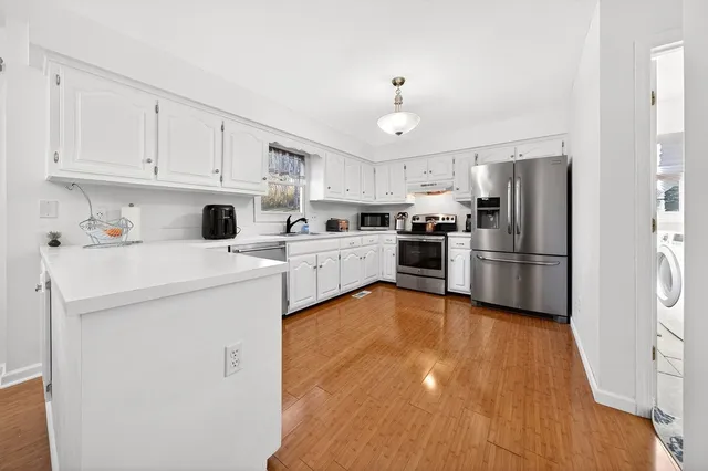 a kitchen with white cabinets and stainless steel appliances