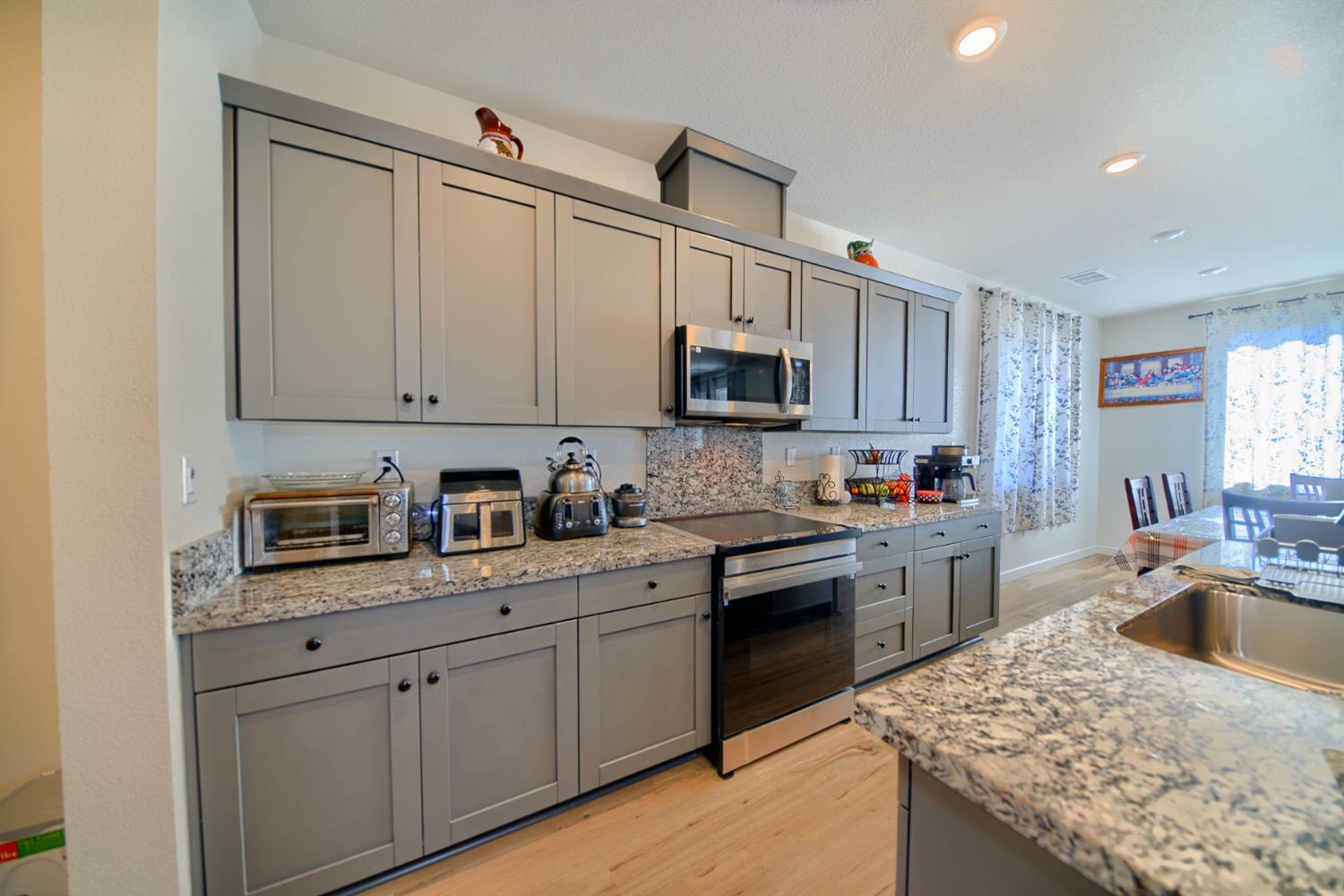 2132 Emerald Rnch Road Patterson, CA 95363 - Photo 45 of 66 a kitchen with granite countertop a sink stainless steel appliances and cabinets
