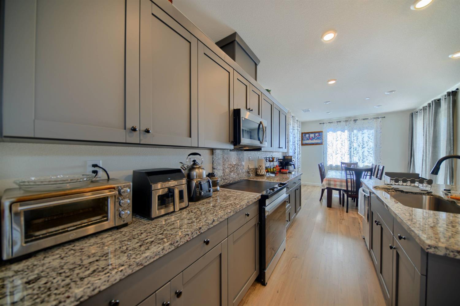 2132 Emerald Rnch Road Patterson, CA 95363 - Photo 48 of 66 a kitchen with stainless steel appliances granite countertop a stove a sink and a microwave