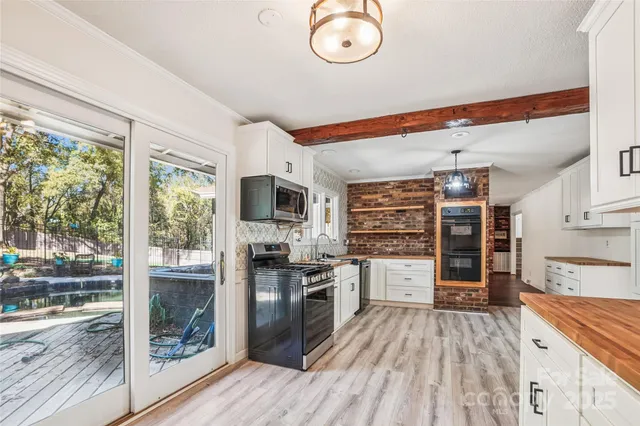 a kitchen with granite countertop a refrigerator oven a sink and dishwasher a stove top oven with wooden floor