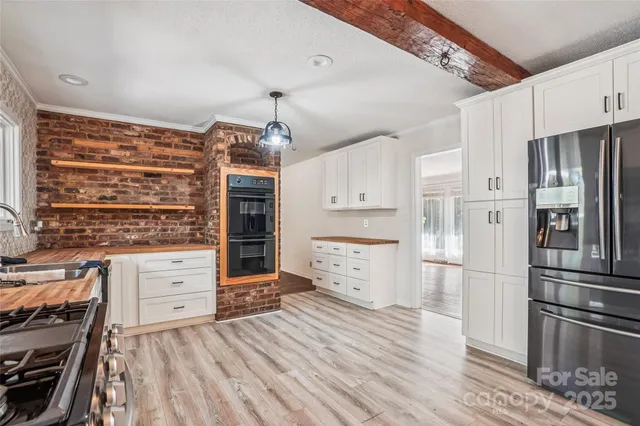 a kitchen with stainless steel appliances granite countertop a lot of counter space and wooden floors