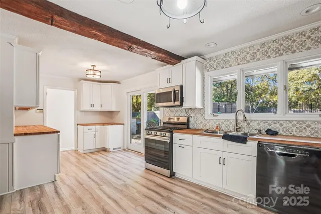 a kitchen with white cabinets and stainless steel appliances