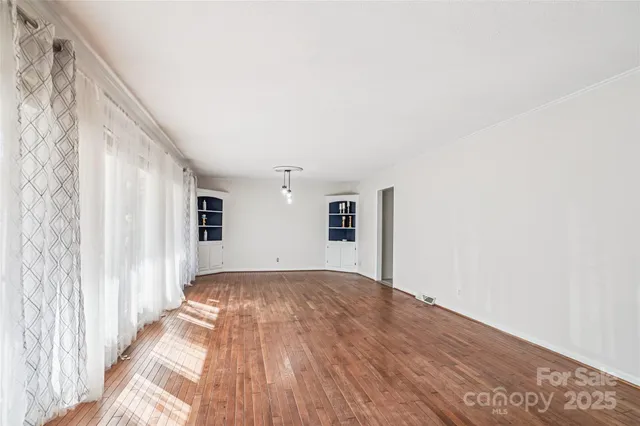 a view of a livingroom with wooden floor and a window