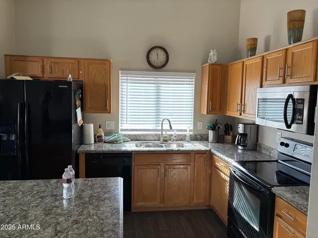 a kitchen with granite countertop a sink stove and refrigerator