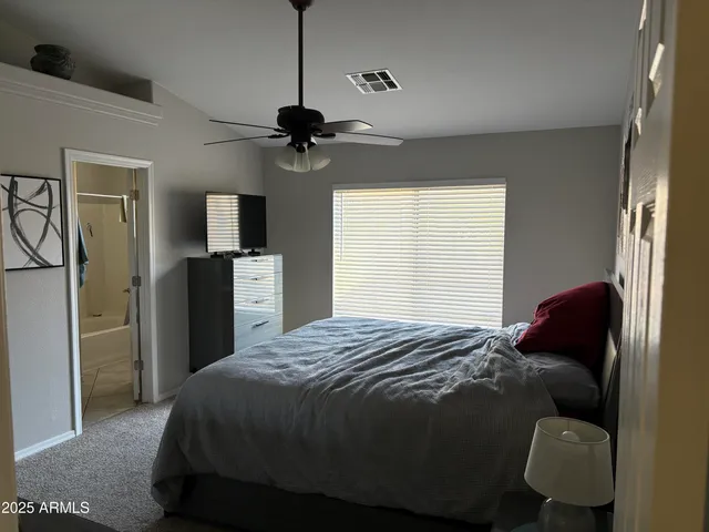 a bedroom with a bed a dresser and mirror
