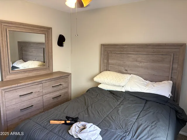 a bedroom with a bed and a chandelier fan
