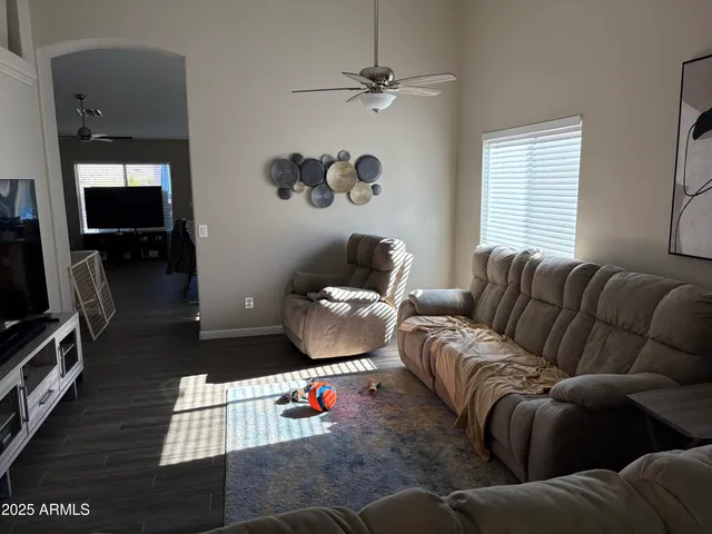 a living room with furniture ceiling fan and a window