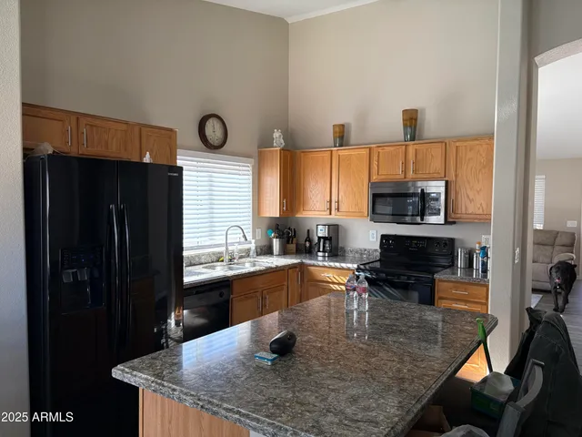 a kitchen with stainless steel appliances granite countertop a sink a stove and a refrigerator