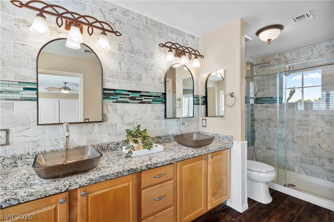 708 Vortex Avenue Henderson, NV 89002 - Photo 32 of 71 Double vessel sinks and granite countertops elevate this well-appointed primary bathroom.