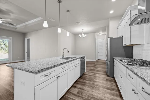 a kitchen with stainless steel appliances granite countertop a stove and a sink